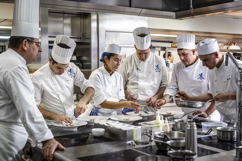John Williams, Executive Chef at The Ritz London, leads his brigade in the kitchen, guiding a team of chefs as they meticulously plate dishes.